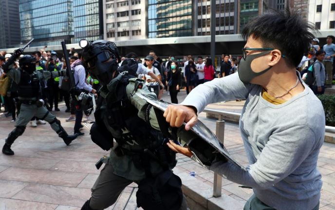 محتج يشتبك مع أحد افراد شرطة مكافحة الشغب في هونج كونج يوم الأربعاء. تصوير: أتيت بيراونجميتا - رويترز